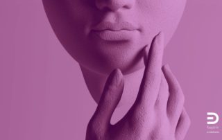 Abstract close-up of a sculptural face in purple tones, with a hand touching the chin. A conceptual image evoking perception and the ways we observe and interpret reality.