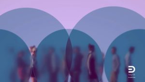 Persone che camminano in uno spazio sfocato, viste attraverso cerchi traslucidi sovrapposti che creano filtri visivi. L’immagine suggerisce l’idea di cornici interpretative che modificano ciò che è visibile e ciò che resta fuori campo.